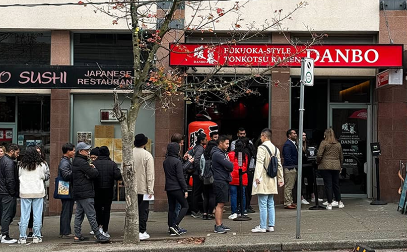Customers waiting in line outside a popular restaurant